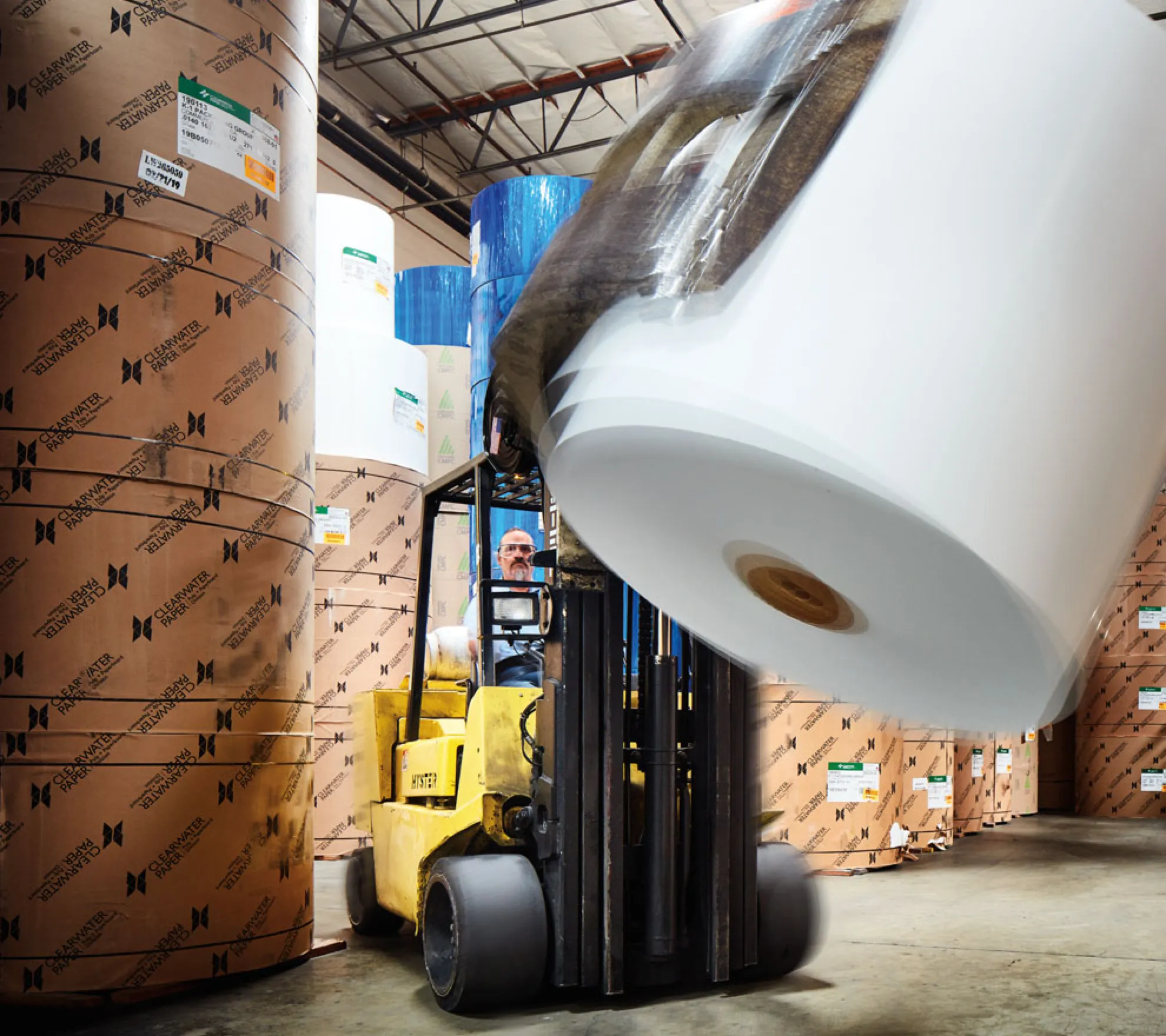 an image of a forklift driver picking up a roll of paper