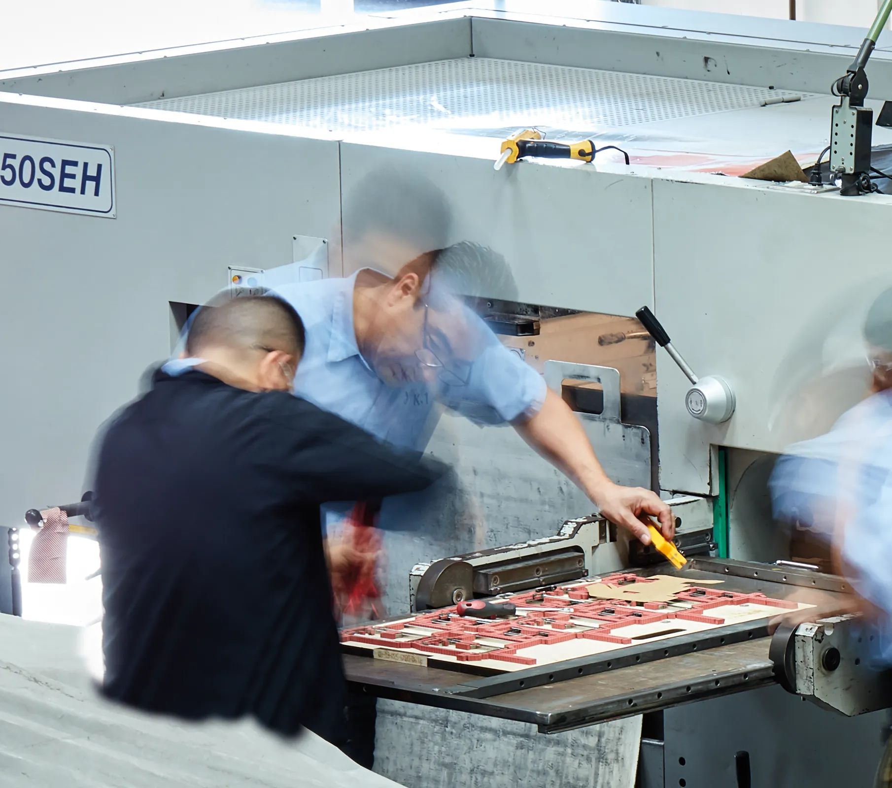 three men working in a factory setting