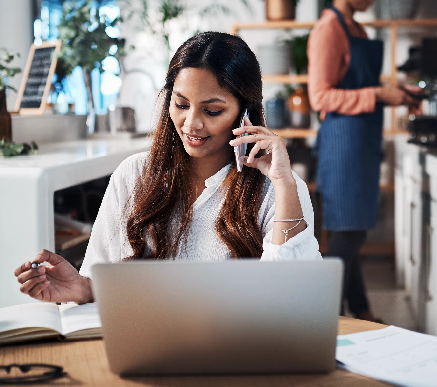 an image of an office worker with a laptop, on a phone call