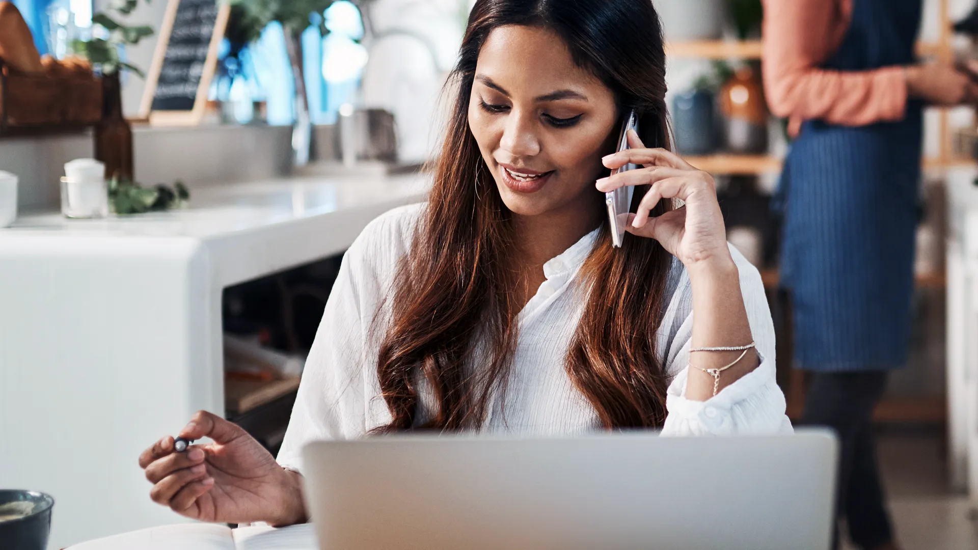 an image of an office worker with a laptop, on a phone call